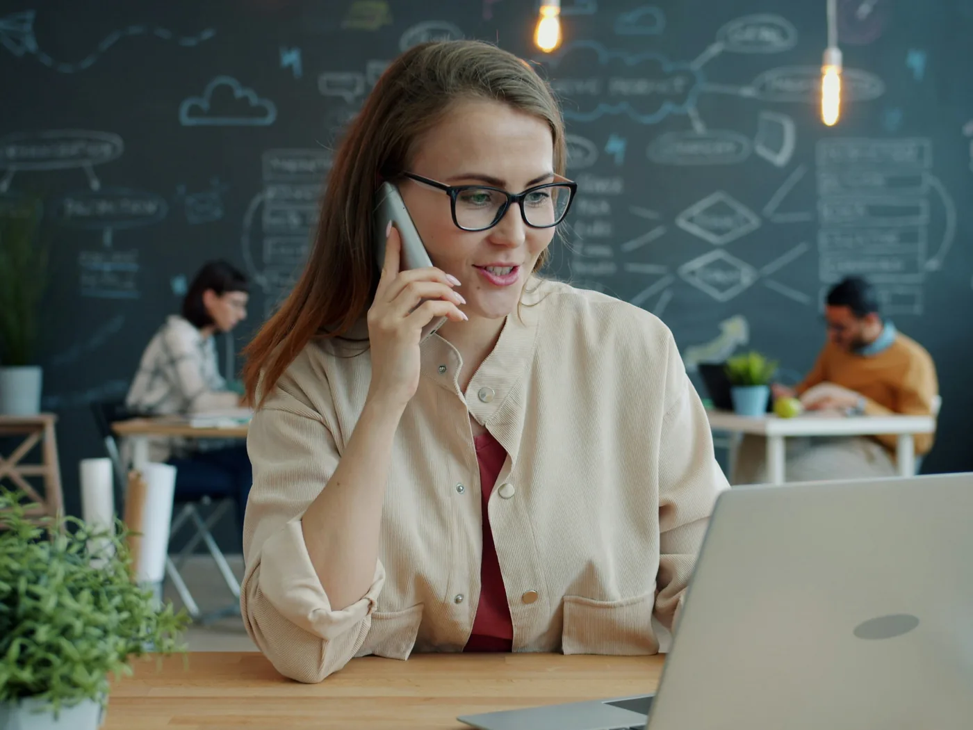 Una compañera de i-Reserve al teléfono con un cliente, con el portátil abierto