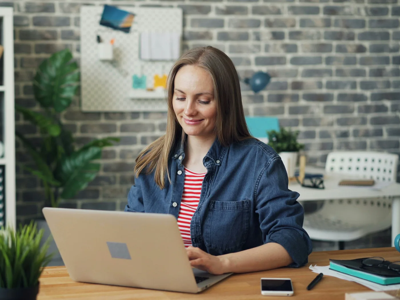 Eine Frau legt lächelnd an ihrem Laptop los